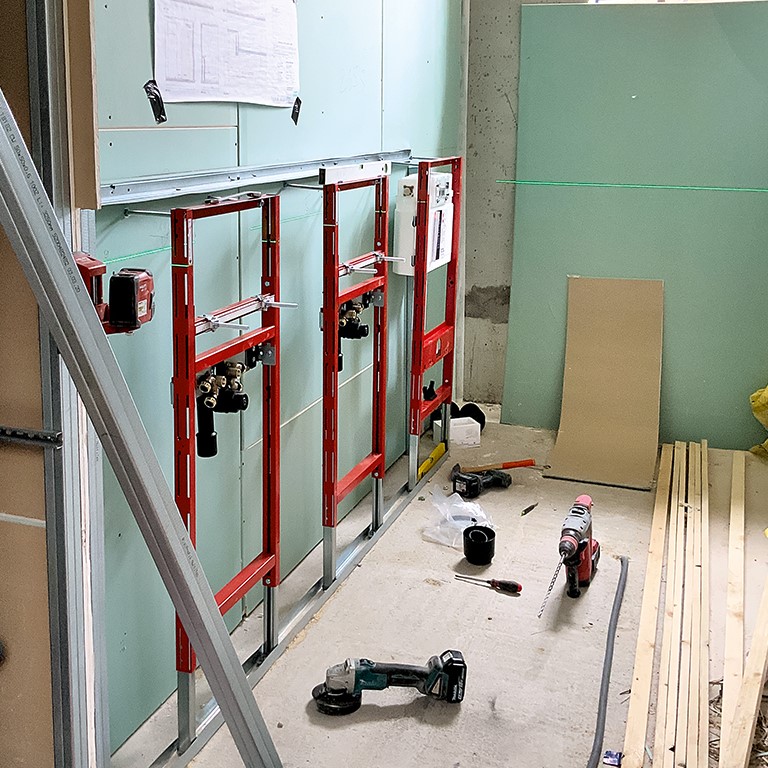Das Bild zeigt die vorgefertigten Register TECEsystem beim Einbau in die ehemalige Panzerhalle in Landau.